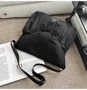 Black tactical messenger bag with large capacity, mesh pockets, and stylish streetwear design.