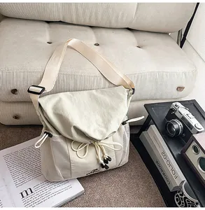 Detail view of the casual canvas messenger bag with mesh pockets and adjustable wide strap.