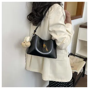 Minimalist versatile underarm shoulder bag with cute plush pendant for daily commuting style.