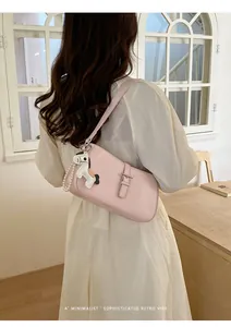 Vue détaillée d'un sac à épaule chic en cuir rose avec charm cheval et lanière de perles.