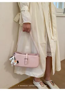 Détail du sac baguette rose élégant avec un joli pendentif cheval et boucle chic.