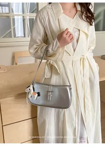 Sac bandoulière argenté métallisé pour femme avec charm cheval et boucle décorative.