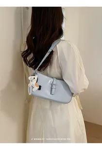 Élégante sacoche d'épaule bleu clair pour femme, sac baguette minimaliste en cuir verni.