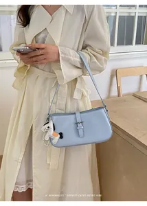 Sac porté épaule bleu clair minimaliste avec charm cheval pour un look chic quotidien.
