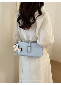 Vue détaillée du sac sous l'aisselle bleu clair minimaliste avec charme de cheval