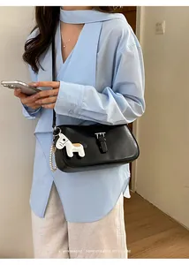 Mannequin portant un sac porté épaule noir minimaliste avec un détail de cheval