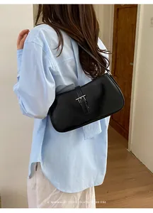 Sac porté épaule noir minimaliste chic pour femme, design rétro à boucle, polyvalent et élégant.