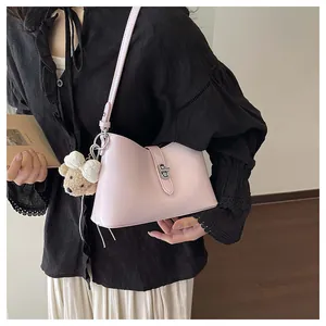 Close-up detail of the pink underarm shoulder bag showcasing the metal lock and cute bear charm.
