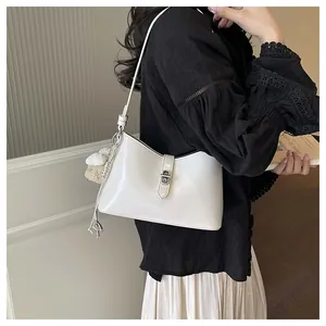 Elegant white underarm shoulder bag with a silver buckle worn by an Asian model
