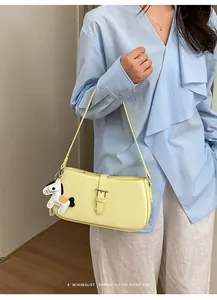 Vue détaillée du sac porté épaule chic en cuir jaune avec charm cheval et boucle rétro.