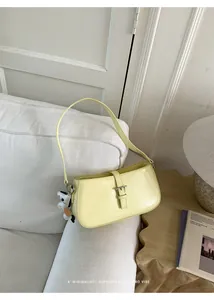 Gros plan d'un sac sous le bras jaune pâle sophistiqué à l'esthétique rétro minimaliste