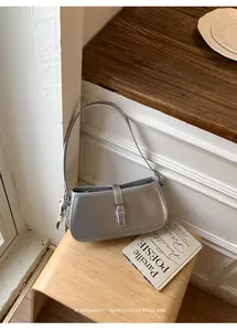 Sac épaule sous les bras argenté minimaliste avec boucle élégante dans un décor rétro.