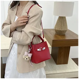 Bolso de cubo en cuero rojo con cierre plateado y dije de perrito de peluche