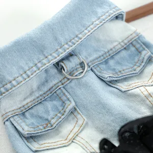 Close-up detail of pet denim dress for small dogs and cats with metal ring and pocket trim.