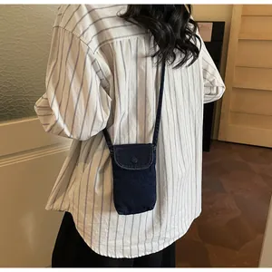 Detail view of a mini denim crossbody phone bag, casual retro style for women everyday use.