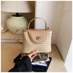 Vue détaillée d'un sac seau en paille fait main avec rabat en cuir pour les vacances
