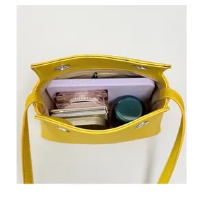 Vista interna dettagliata di una borsa a tracolla in pelle gialla che mostra la sua capacità