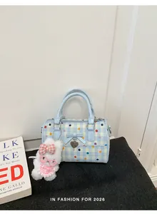 Bolso de mano azul a lunares con lindo dije de conejo sobre una superficie oscura