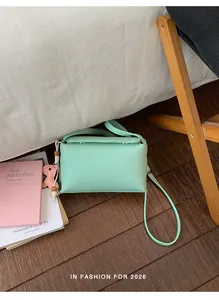 Dettaglio di una borsa a tracolla verde menta minimalista in un ambiente accogliente