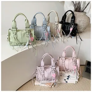 Detailed view of stylish motorcycle handbags in pastel colors with tassels and charms