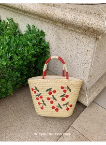 Handgemaakte rieten tas met kersenvlechten en gestreepte handvatten voor het strand