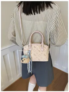 Pink PU leather crossbody bag with cute cat print and fluffy bear charm detail.