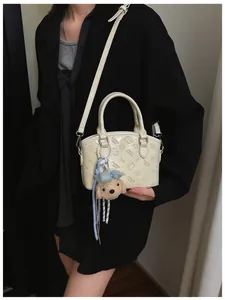 Chic Korean style shoulder bag with cartoon embossed pattern and cute plush dog pendant.