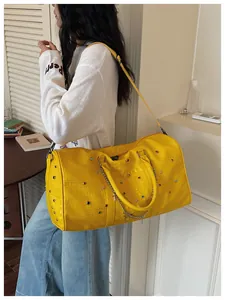 Detailansicht der gelben Krokodilmuster Reisetasche mit Strass und Metallkette.