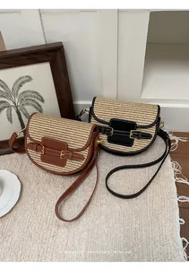 Elegant woven straw saddle bags with brown and black faux leather trims for beach vacation