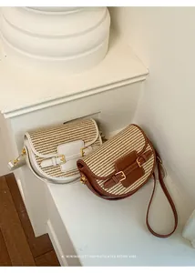 Detail view of two straw woven saddle bags in white and brown for beach vacations