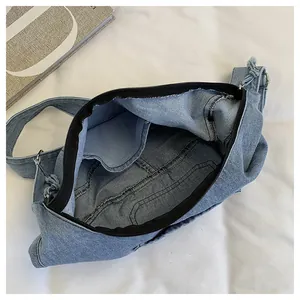 Detailed view of the interior compartment and lining pocket of denim dumpling bag