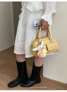 Exquisite yellow Boston bag with crochet rabbit charm in a minimalist retro style