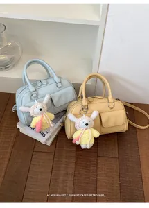 Close-up of retro Boston handbags in blue and yellow showing cute rabbit charms.