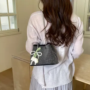 Detailed view of rhinestone bucket bag with chain strap and pearl tulip charm pendant