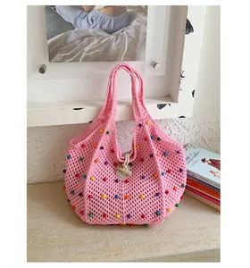 Vista detallada del bolso de ganchillo rosa con detalles de cuentas de colores