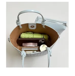 Detailed top view of the spacious interior of a light blue bucket bag with essentials