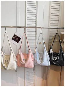 Stilosa borsa a tracolla grande e capiente con stampa stelle, catena di perle e fiocco colorato.
