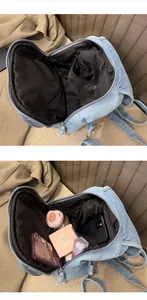 Detail view showing the spacious black-lined interior of the light blue denim backpack