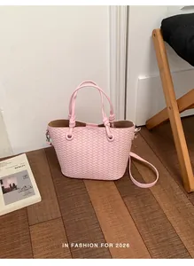 Detailed view of the pink woven texture bucket bag placed on a wooden floor surface