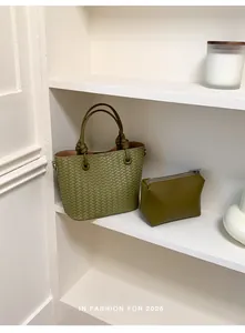 Olive green woven bucket bag with matching inner pouch on minimalist white shelves.