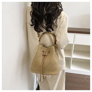 Sac seau en paille élégant avec poignée en bambou, idéal pour les vacances à la plage et quotidien.
