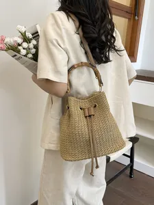 Sac seau en paille élégant avec poignée en bambou, idéal pour les vacances à la plage d'été.