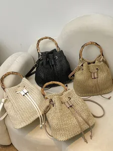 Élégant sac seau pour femme en paille tissée avec poignée en bambou pour plage chic.