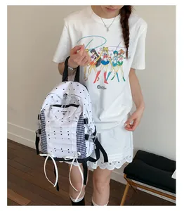 Detailed view of a white lightweight travel backpack with polka dots and checkered side pockets