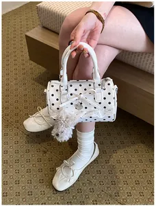 Chic white polka dot pillow bag detail showcasing cute bow, lace trim and fluffy plush charm.