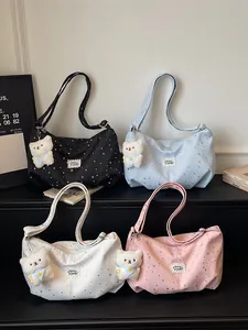 Elegante borsa a tracolla con stampa a stelle e ciondolo orsetto per look casual.