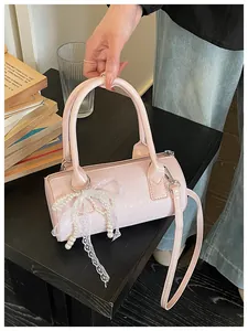 Elegant pink cylinder barrel bag featuring decorative pearl lace bow and embossed star pattern