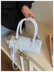 Elegant light blue cylindrical handbag with decorative pearl lace keychain detail
