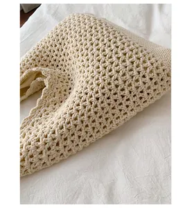 Detail view showing the intricate crochet texture of the beige woven beach tote bag