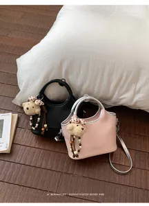 Mini-sacs seaux rose et noir avec adorables breloques ours sur un sol en bois sombre